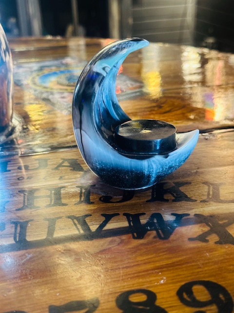 Handmade resin moon candle holders by Trashmagick Alchemy. Custom altar décor with unique colors, glitter, shimmer, and cosmic designs.