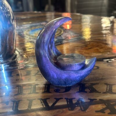 Handmade resin moon candle holders by Trashmagick Alchemy. Custom altar décor with unique colors, glitter, shimmer, and cosmic designs.